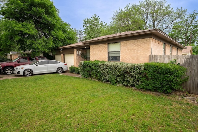 view of front facade with a garage, fence, a front lawn, and brick siding