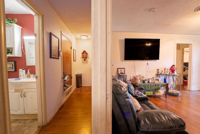 living area with a textured ceiling and wood finished floors