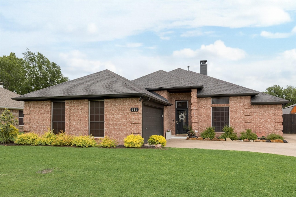 view of front of home with brick siding, a garage, a chimney, and concrete driveway