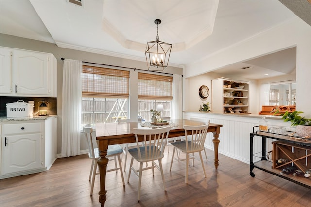 111 Princeton Cir, Forney, TX 75126 - dining room with an inviting chandelier, ornamental molding, built in features, a tray ceiling, and light wood-style flooring