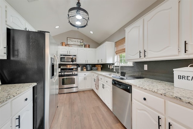 111 Princeton Cir, Forney, TX 75126 - kitchen featuring a sink, light wood finished floors, stainless steel appliances, white cabinetry, and lofted ceiling