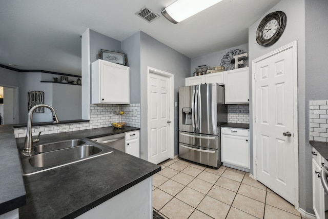 10602 Greenbriar Ln, Rowlett, TX 75089 - kitchen with white cabinets, dark countertops, a sink, stainless steel appliances, and decorative backsplash
