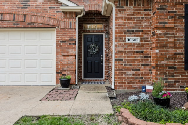 10602 Greenbriar Ln, Rowlett, TX 75089 - doorway to property with an attached garage, driveway, and brick siding