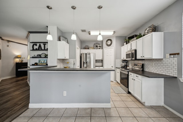 10602 Greenbriar Ln, Rowlett, TX 75089 - kitchen featuring dark countertops, stainless steel appliances, a peninsula, decorative backsplash, and visible vents