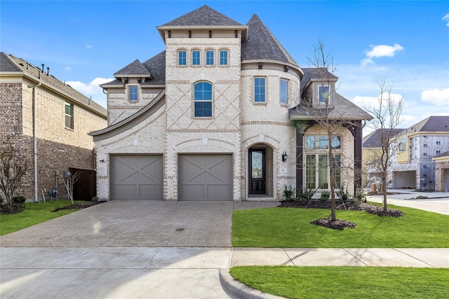 french country home with driveway, brick siding, a front lawn, an attached garage, and a shingled roof