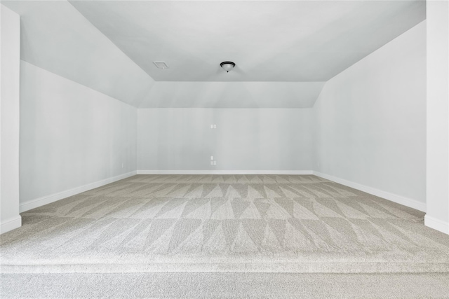 additional living space featuring carpet floors, baseboards, and lofted ceiling