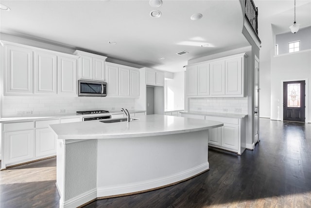 kitchen featuring decorative backsplash, visible vents, a sink, stainless steel appliances, and a wealth of natural light