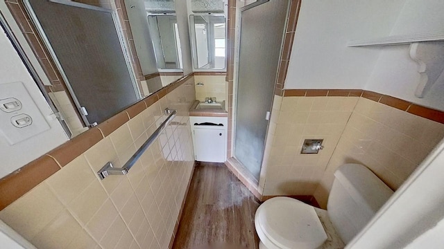 700 N Scarlett Dr, Lacy Lakeview, TX 76705 - full bath featuring wood finished floors, toilet, tile walls, a sink, and a stall shower