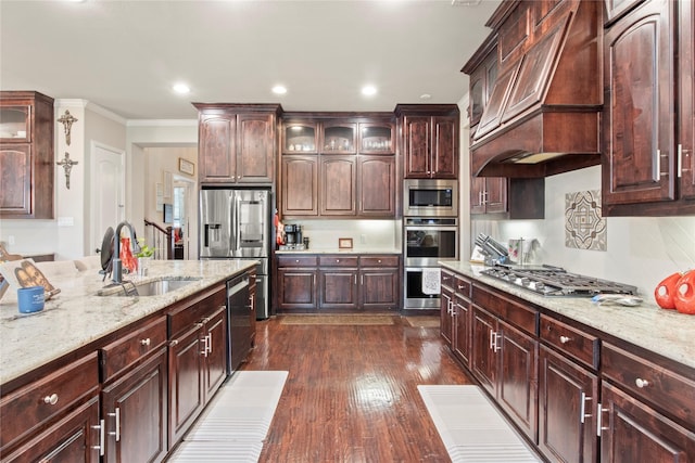 8225 Bonny Bank, The Colony, TX 75056 - kitchen with stainless steel appliances, a sink, premium range hood, crown molding, and dark wood-type flooring