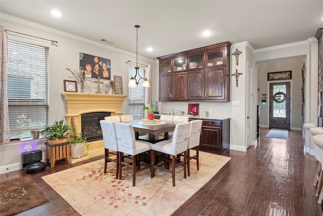 8225 Bonny Bank, The Colony, TX 75056 - dining space with a glass covered fireplace, wood finished floors, plenty of natural light, baseboards, and crown molding