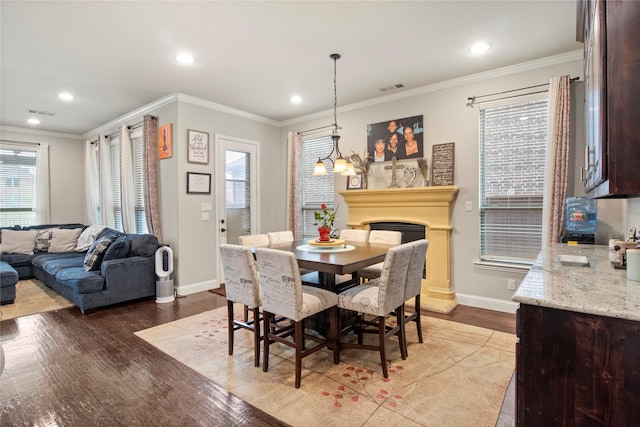 8225 Bonny Bank, The Colony, TX 75056 - dining area featuring baseboards, wood finished floors, recessed lighting, crown molding, and a fireplace with raised hearth