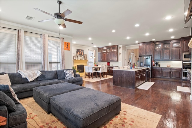 8225 Bonny Bank, The Colony, TX 75056 - living room with ornamental molding, ceiling fan, dark wood-style floors, and recessed lighting