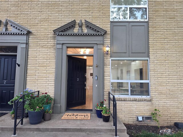 entrance to property featuring crawl space and brick siding