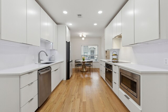 kitchen with stainless steel appliances, a sink, and modern cabinets