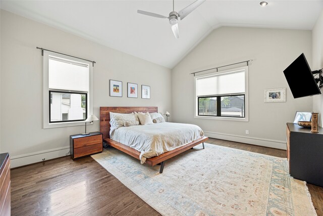 bedroom featuring a ceiling fan, wood finished floors, baseboard heating, and multiple windows