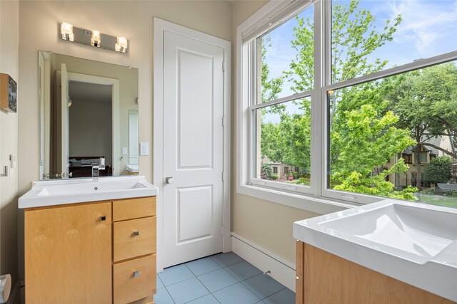 bathroom featuring tile patterned floors, baseboards, and vanity