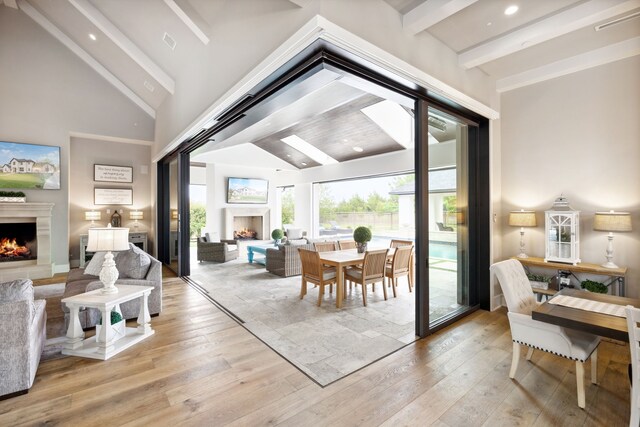 interior space with recessed lighting, beamed ceiling, a lit fireplace, and hardwood / wood-style flooring