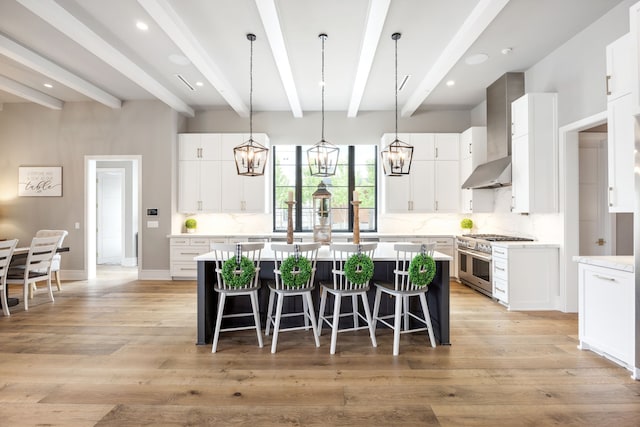 kitchen featuring beam ceiling, a center island, wall chimney exhaust hood, backsplash, and double oven range