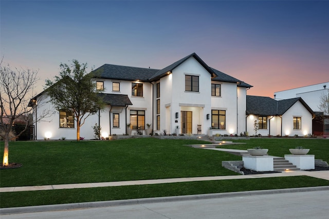 modern farmhouse with stucco siding and a yard