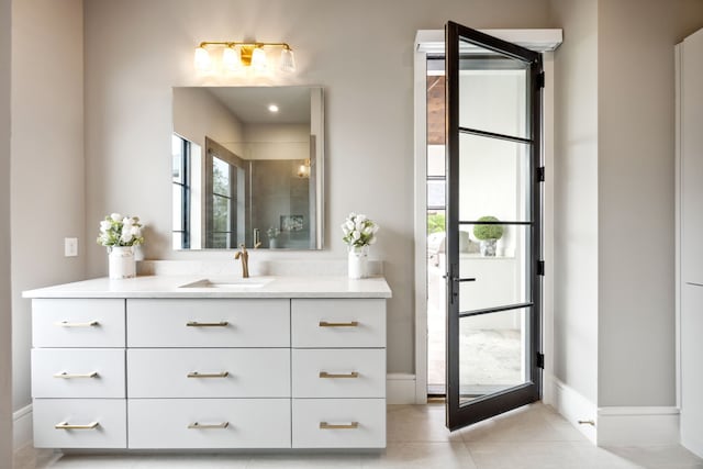 full bathroom with vanity, a wealth of natural light, baseboards, tile patterned floors, and a tile shower