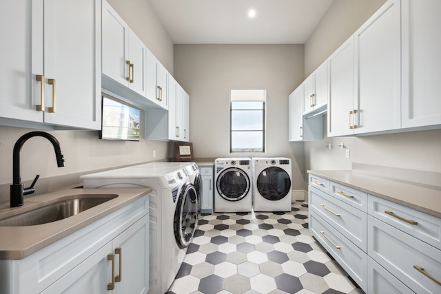 laundry area featuring washing machine and clothes dryer, cabinet space, a sink, light floors, and recessed lighting