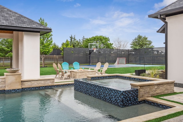 view of swimming pool with fence, a patio, and a pool with connected hot tub