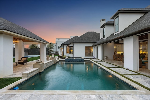 exterior space with a patio area and a pool with connected hot tub