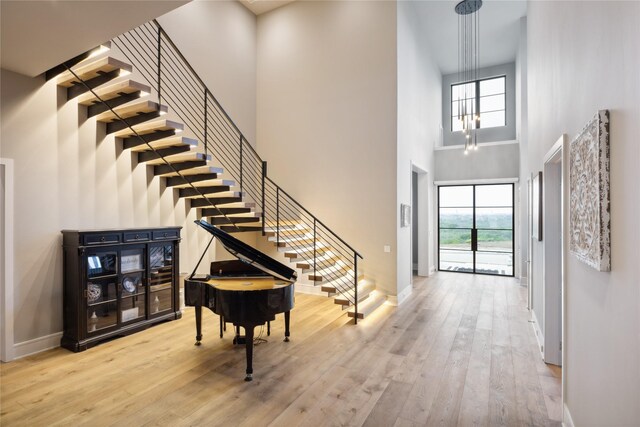 entrance foyer featuring stairs, a high ceiling, a wealth of natural light, and wood finished floors