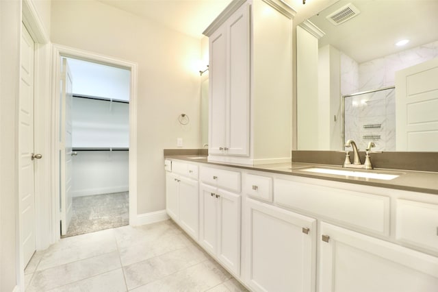4713 Piedras Lanzar Dr, Mckinney, TX 75070 - full bathroom with double vanity, a walk in closet, visible vents, a shower stall, and a sink