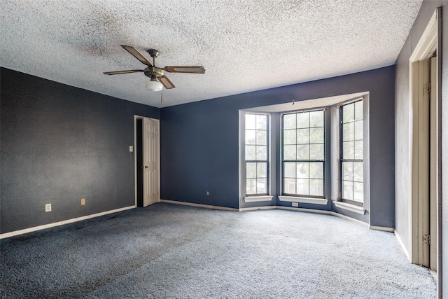 empty room with baseboards, ceiling fan, and carpet flooring