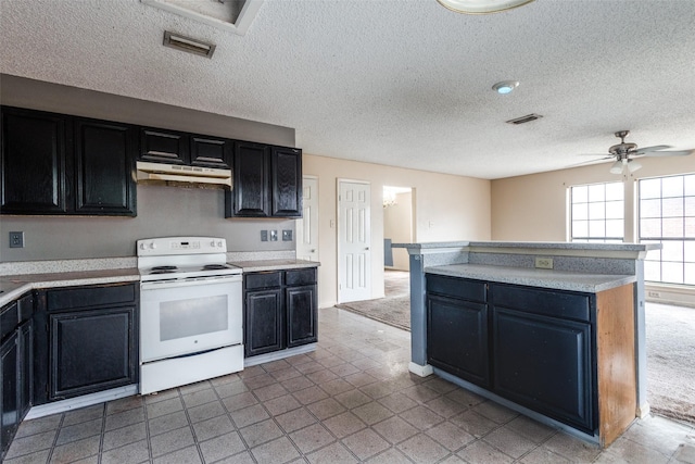 kitchen with light countertops, dark cabinetry, white range with electric stovetop, and visible vents