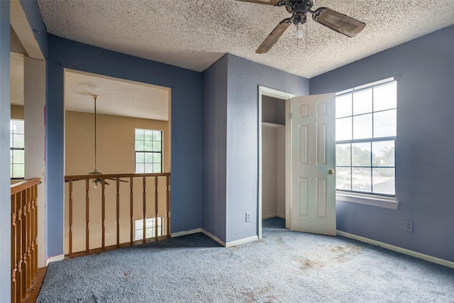 unfurnished bedroom with baseboards, carpet, a ceiling fan, and a textured ceiling