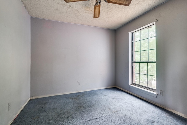 carpeted empty room with plenty of natural light, a textured ceiling, ceiling fan, and baseboards