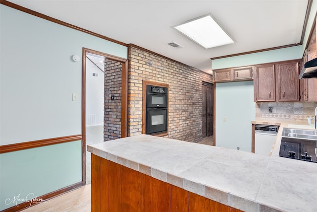 5220 Linton Cutoff Rd, Benton, LA 71006 - kitchen featuring dobule oven black, backsplash, a sink, a peninsula, and light wood-style floors