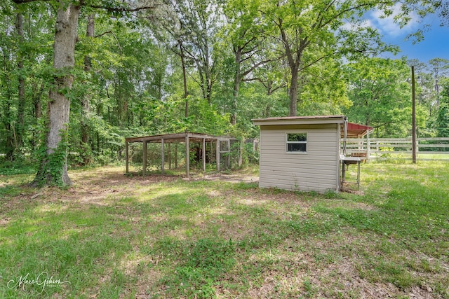 5220 Linton Cutoff Rd, Benton, LA 71006 - view of yard with fence, a detached carport, an outbuilding, and a forest view