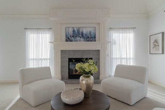 living area with baseboards, ornamental molding, a fireplace, and carpet flooring