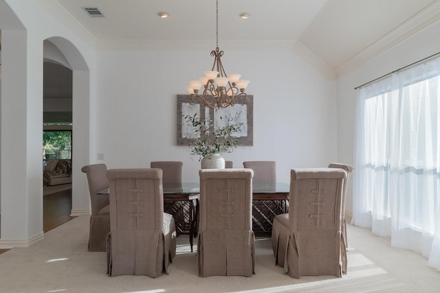 carpeted dining space with arched walkways, visible vents, ornamental molding, and a notable chandelier