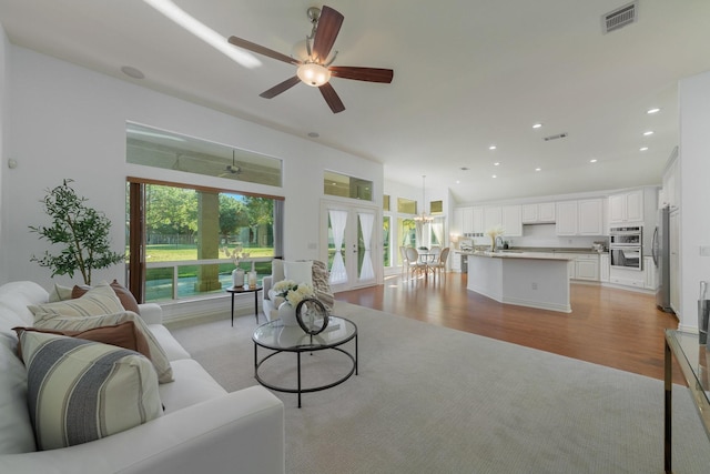 living area with visible vents, a ceiling fan, light wood finished floors, and recessed lighting