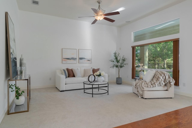 carpeted living room featuring baseboards, ceiling fan, and visible vents