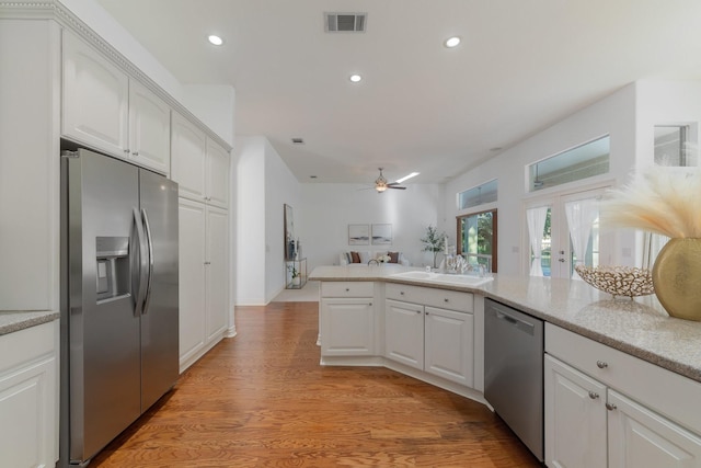 kitchen with ceiling fan, stainless steel appliances, white cabinetry, and visible vents