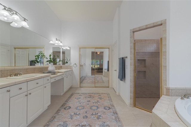 full bathroom featuring a garden tub, vanity, ceiling fan, tiled shower, and tile patterned floors