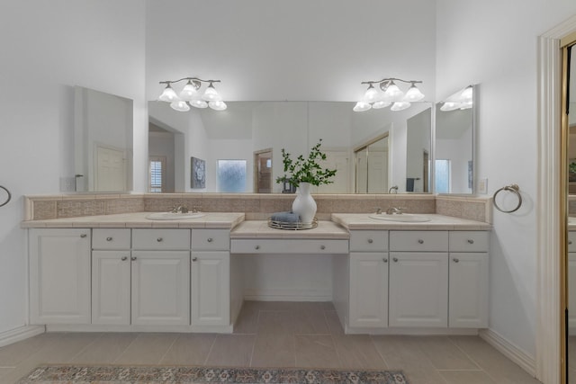 bathroom with double vanity, a sink, and tile patterned floors