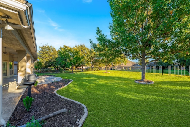 view of yard featuring a fenced backyard, a ceiling fan, and a patio area