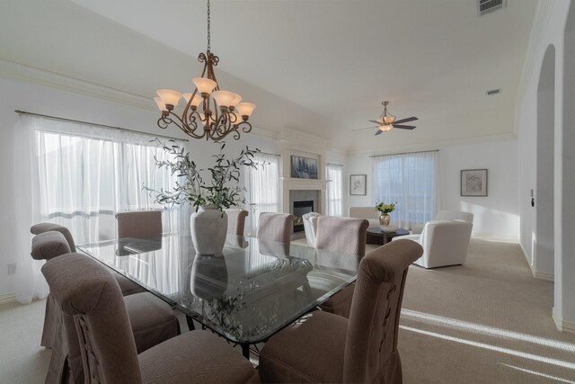 dining area with visible vents, arched walkways, ceiling fan with notable chandelier, and light colored carpet