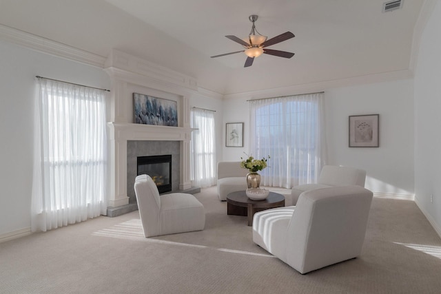 carpeted living area featuring visible vents, a ceiling fan, a healthy amount of sunlight, and a tile fireplace