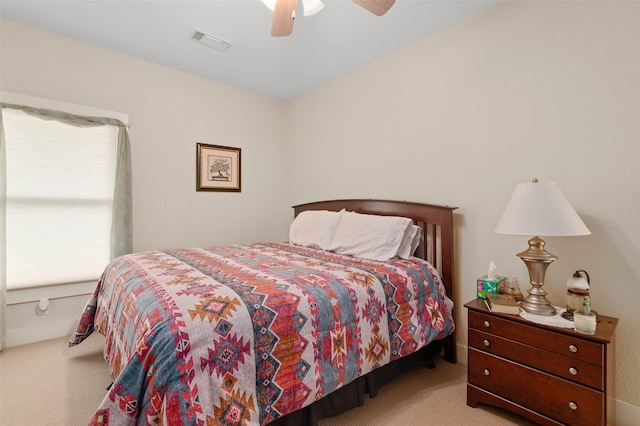 carpeted bedroom with visible vents and a ceiling fan