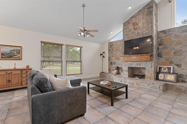 living room featuring ceiling fan, a stone fireplace, light tile patterned floors, and lofted ceiling