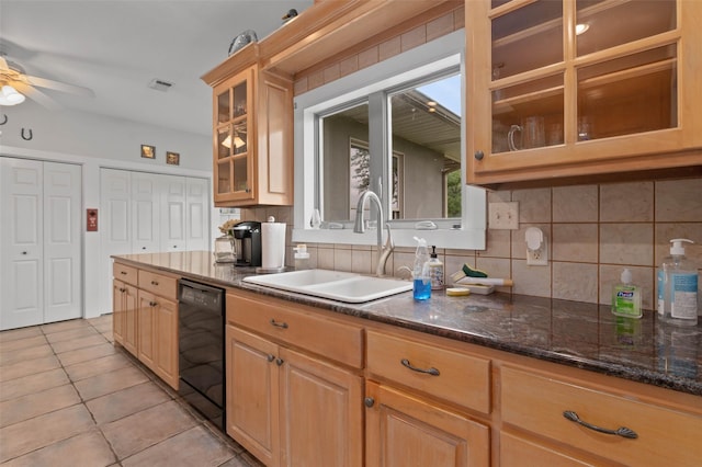 kitchen with a sink, light tile patterned floors, tasteful backsplash, and black dishwasher