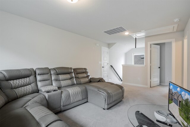 carpeted living area with baseboards, visible vents, and attic access