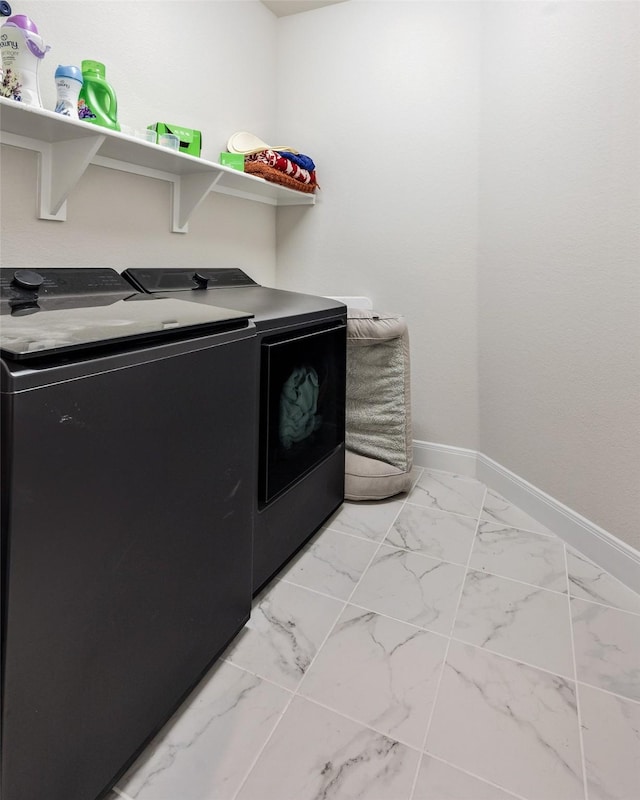 clothes washing area with washing machine and clothes dryer, laundry area, baseboards, and marble finish floor
